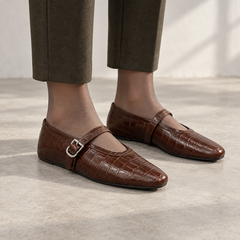 Brown croc-embossed oil-waxed leather buckle-strap flats worn with olive cropped trousers and sheer hosiery
