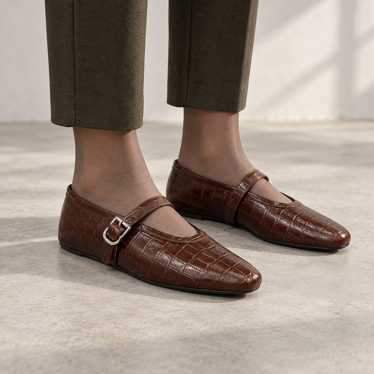 Brown croc-embossed oil-waxed leather buckle-strap flats worn with olive cropped trousers and sheer hosiery