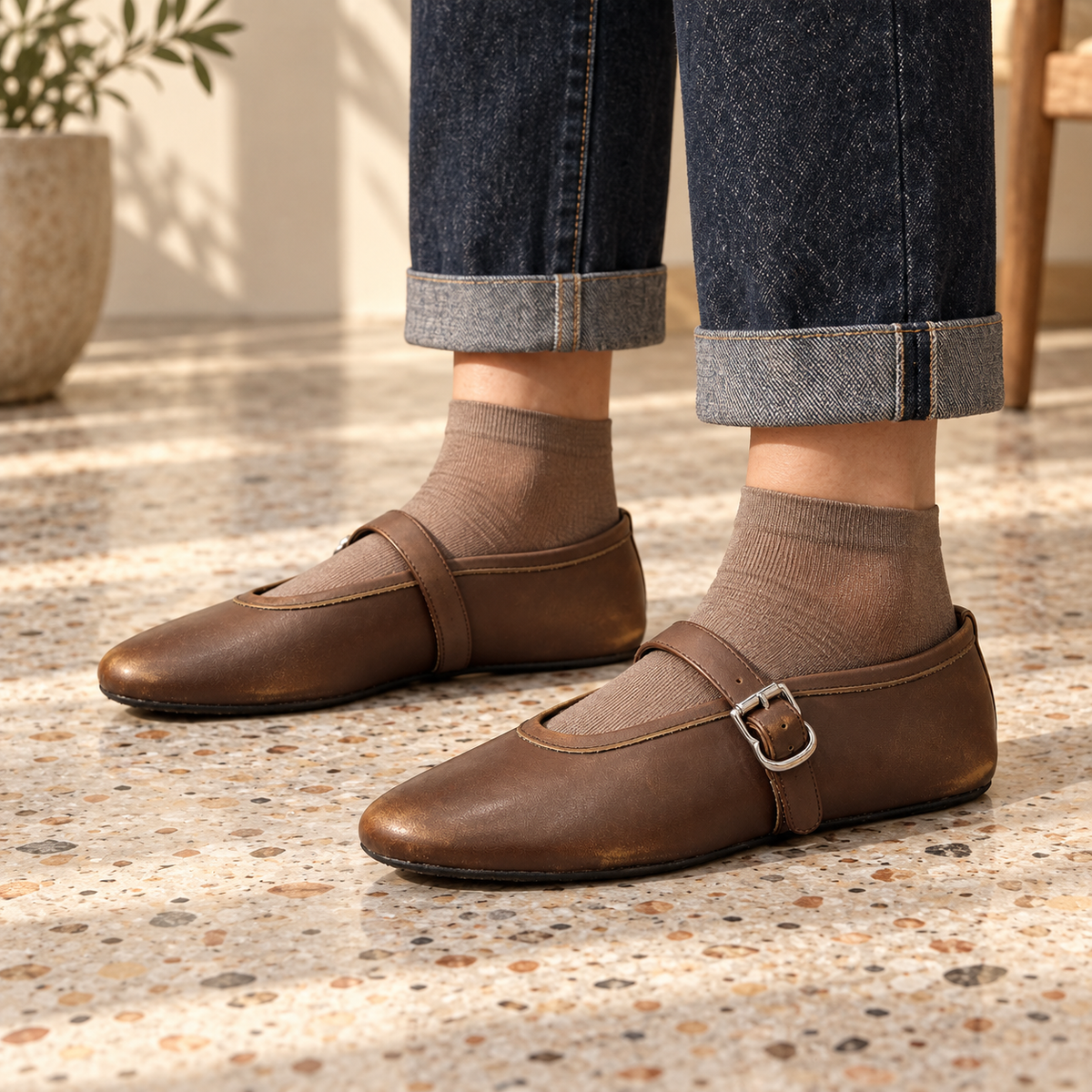 Brown oil-waxed leather buckle-strap flats worn with cuffed indigo jeans and taupe socks