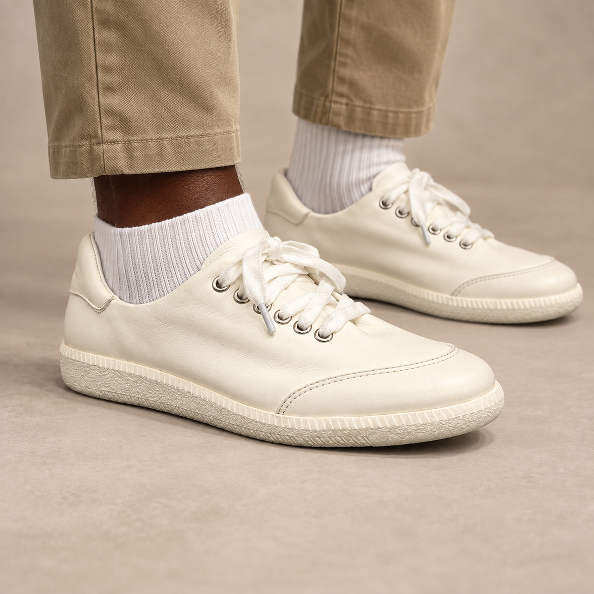White top-grain leather lace-up sneakers worn with khaki trousers and white socks