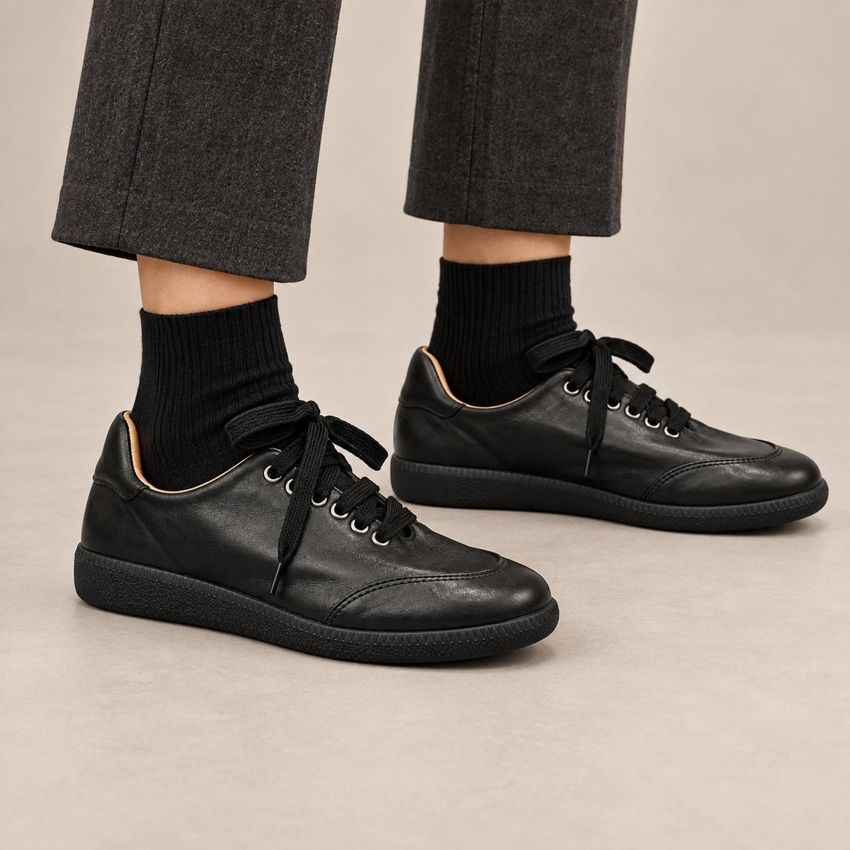 Black top-grain leather lace-up Mary Jane sneakers worn with charcoal cropped trousers and black socks