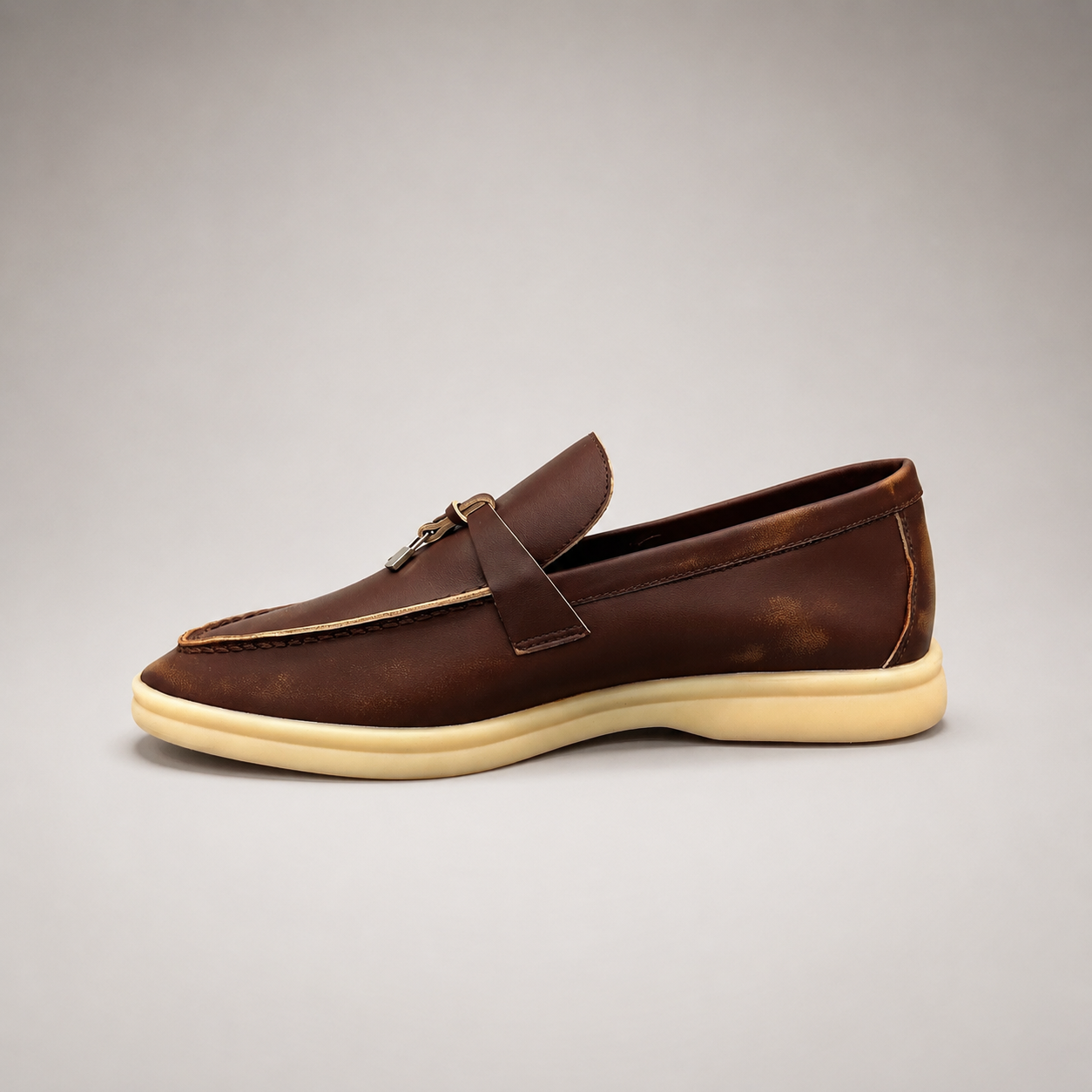 Brown loafer side profile showing a metal accent across the vamp