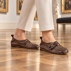 Brown double-buckle split-toe flats worn on feet