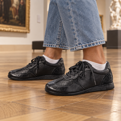 Black sneakers worn on feet