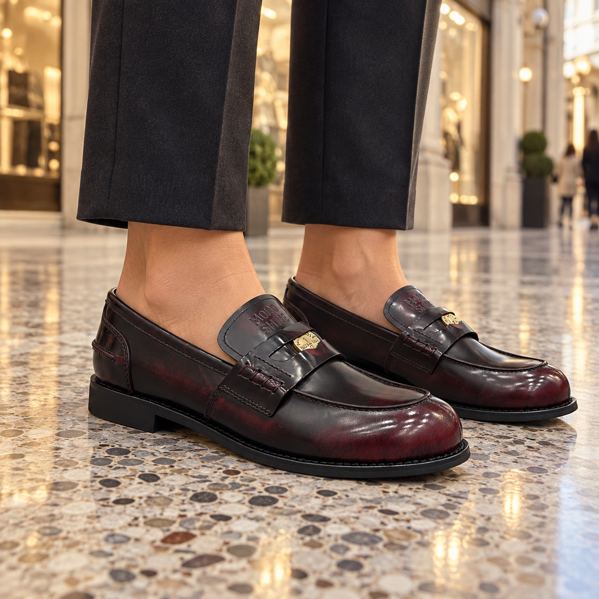 Burgundy emblem loafers worn on feet