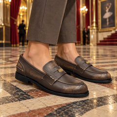 Brown emblem loafers worn on feet