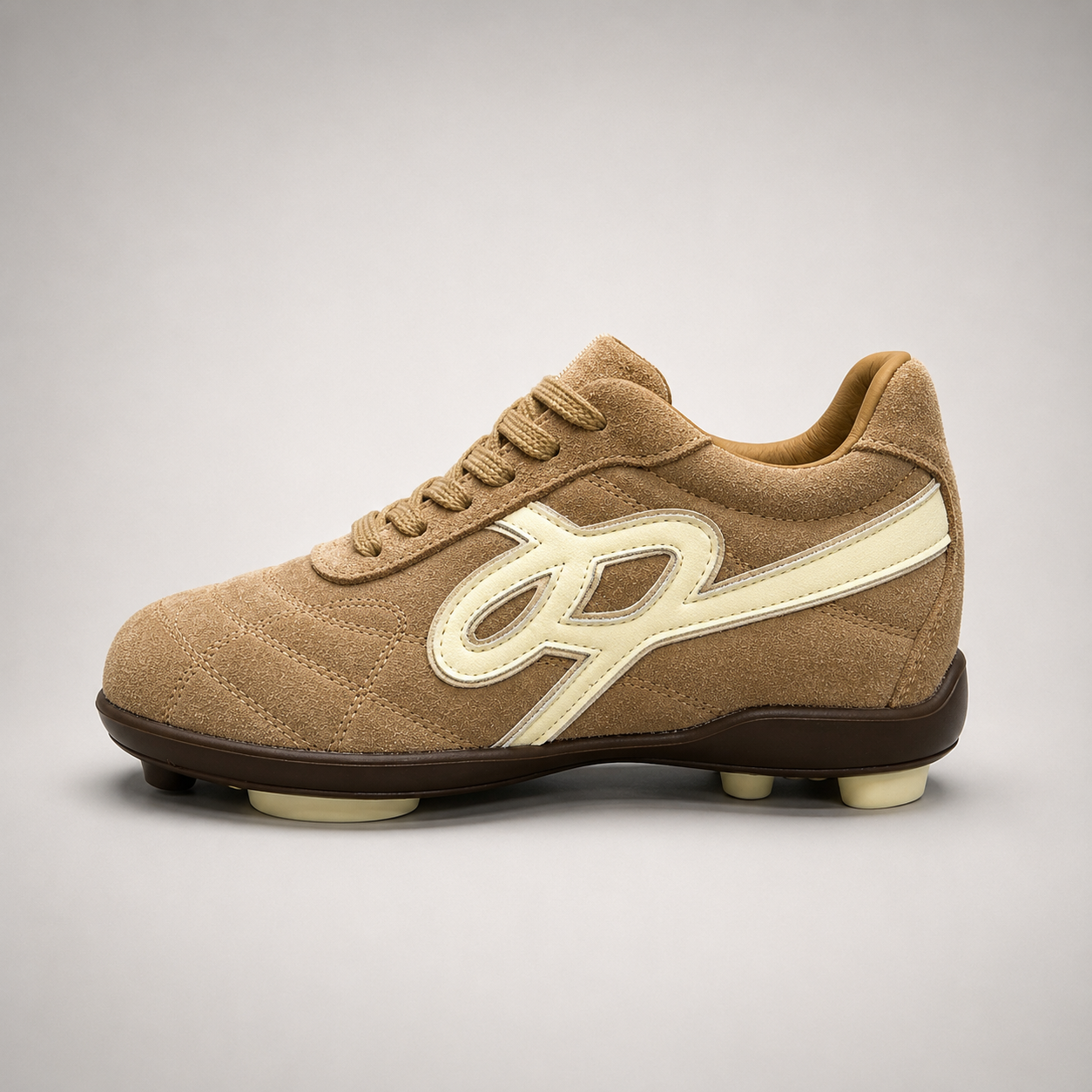Tan soccer shoe opposite side profile showing a lace-up upper and molded outsole studs
