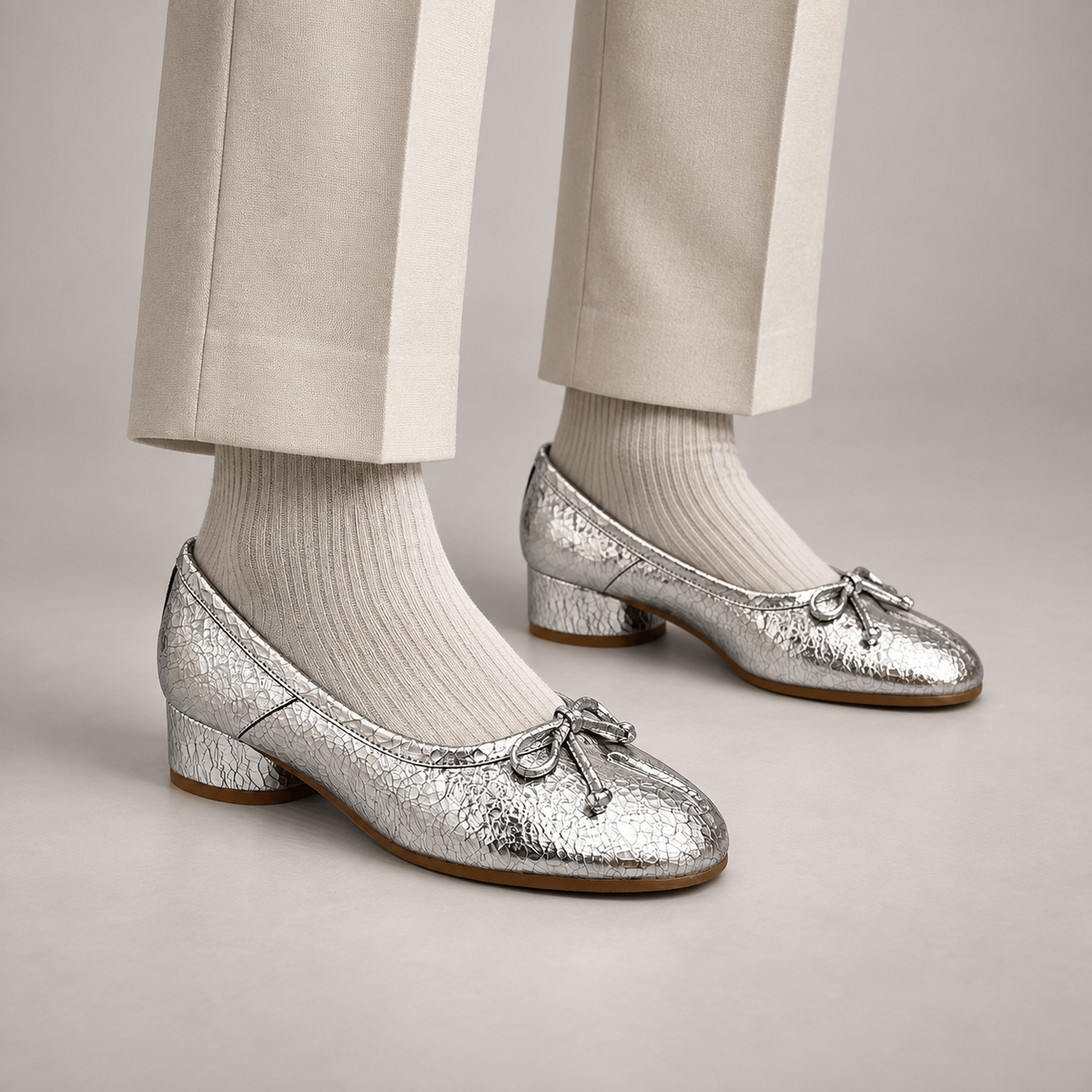 Silver Textured Leather Split-Toe Bow Block-Heel Flats worn on foot