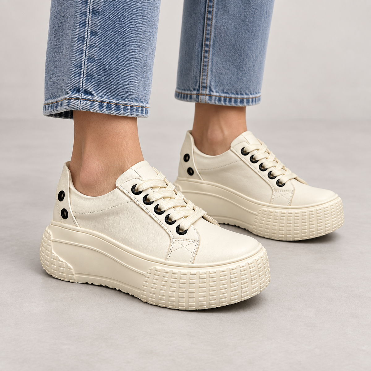 Cream platform lace-up sneakers worn on foot