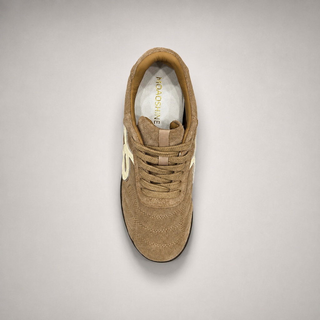 Tan soccer shoe top view showing a lace-up upper and molded outsole studs