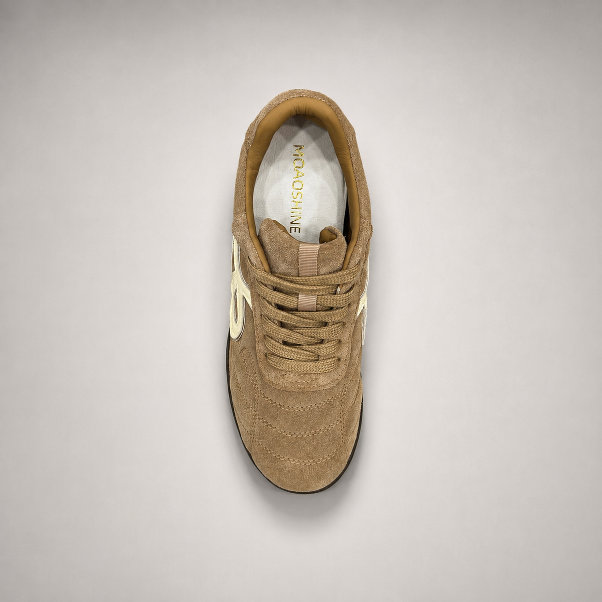 Tan soccer shoe top view showing a lace-up upper and molded outsole studs