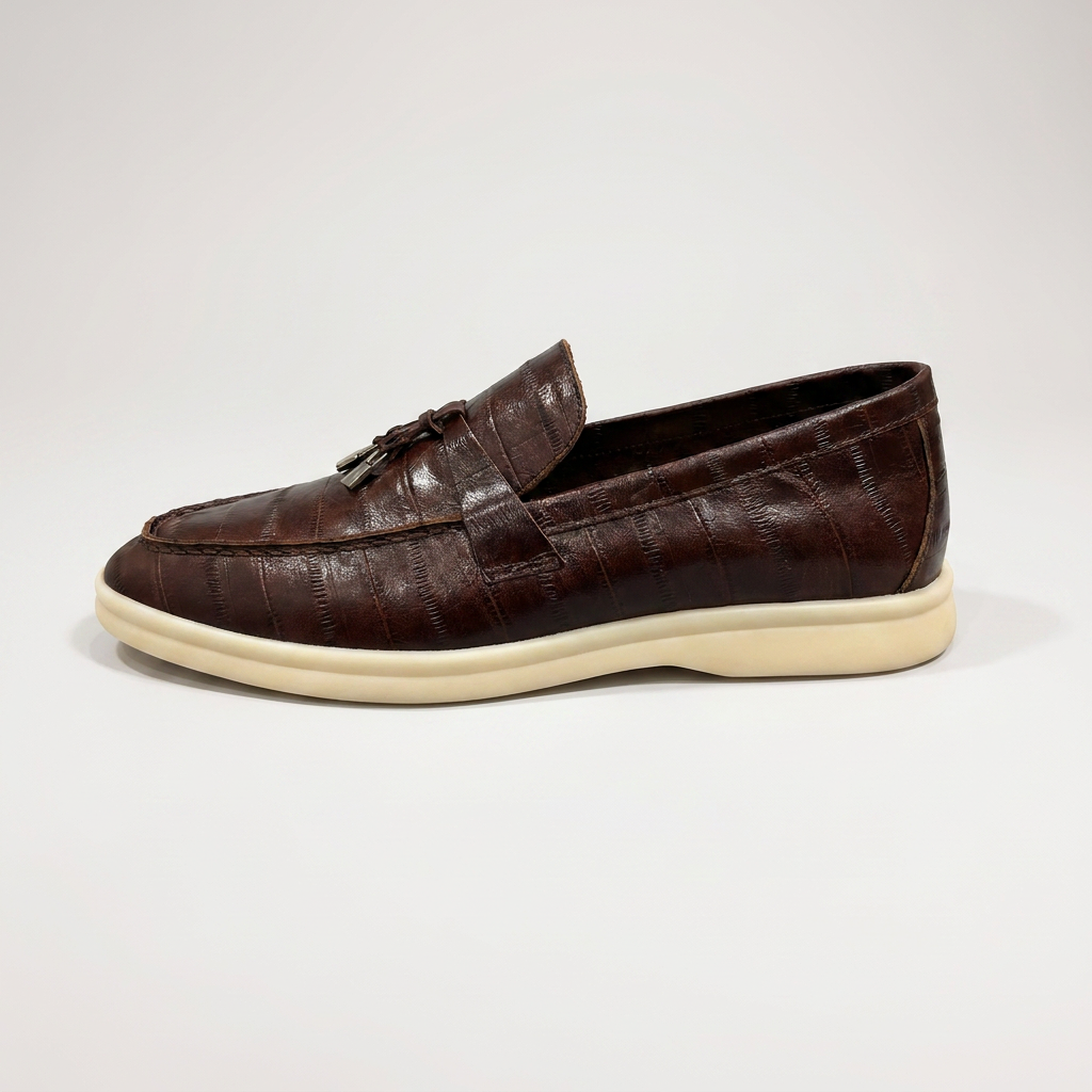 Brown loafer inner side profile showing an eel-pattern embossed vamp and tassel detail