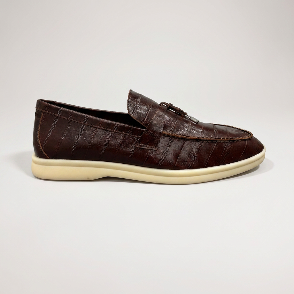 Brown loafer outer side profile showing an eel-pattern embossed vamp and tassel detail