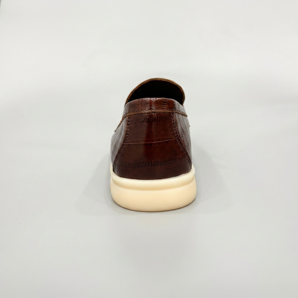 Brown loafer rear view showing an eel-pattern embossed vamp and tassel detail