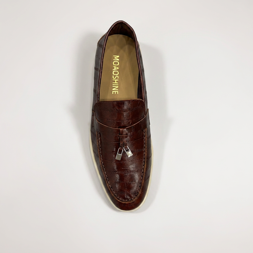 Brown loafer top view showing an eel-pattern embossed vamp and tassel detail