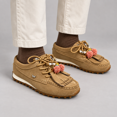 Tan suede fringe-and-tassel moccasin loafers worn with ivory chinos and brown socks