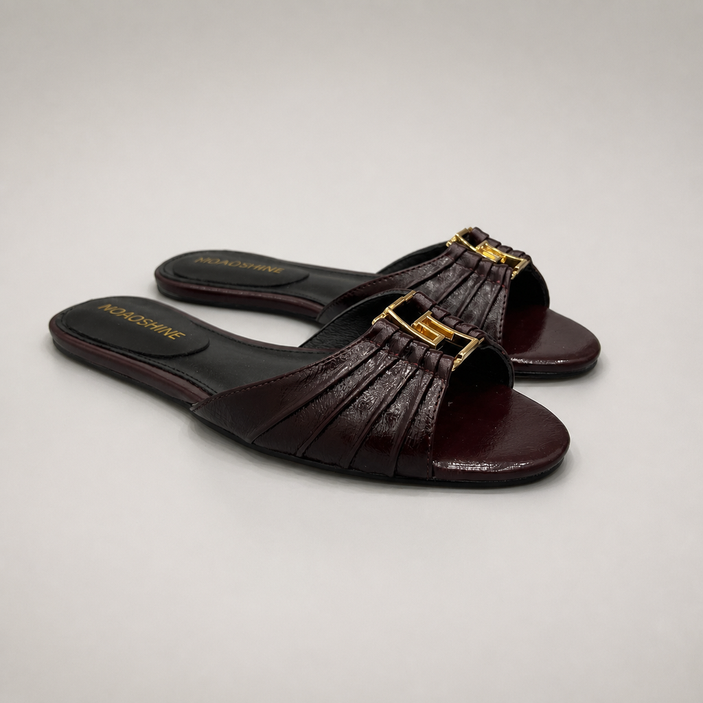 Brown slide sandal pair three-quarter view showing a pleated forefoot strap