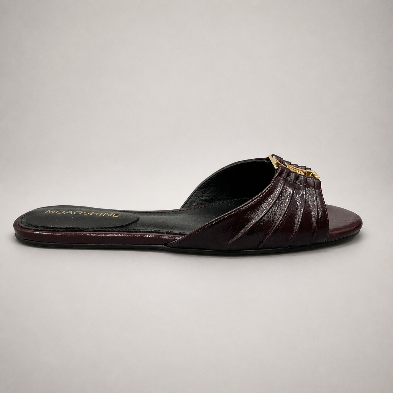 Brown slide sandal side profile showing a pleated forefoot strap