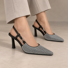 Gray pointed-toe double-strap slingback pumps worn with stone trousers
