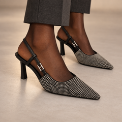 Gray pointed-toe double-strap slingback pumps worn with charcoal trousers