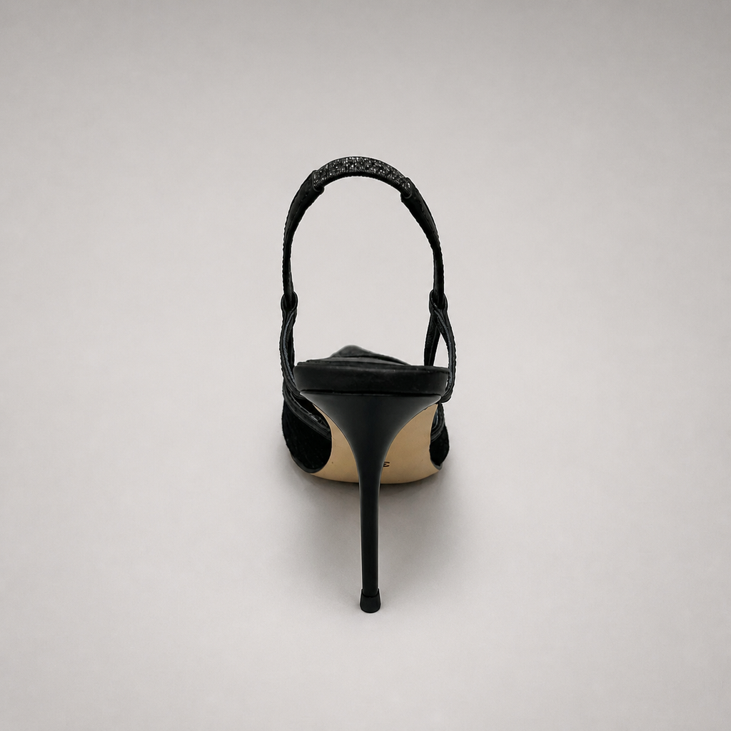 Black slingback pump rear view showing a pointed toe and lace-panel upper