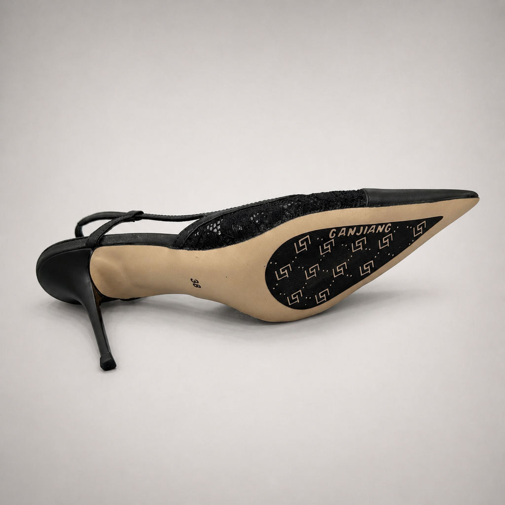 Black slingback pump top view showing a pointed toe and lace-panel upper