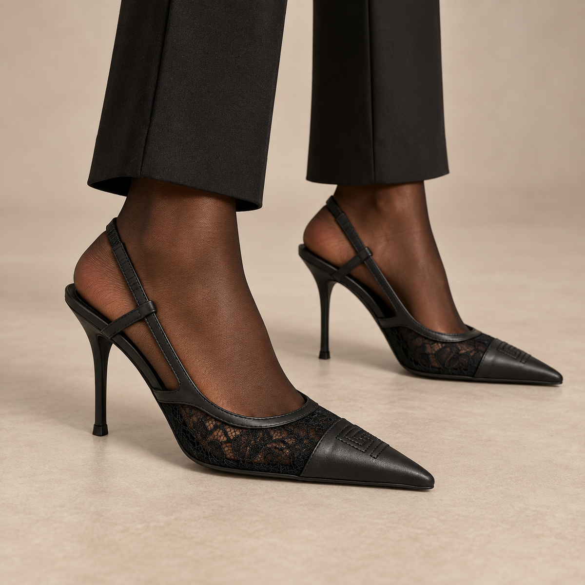 Black lace-panel pointed-toe slingback pumps worn with black trousers