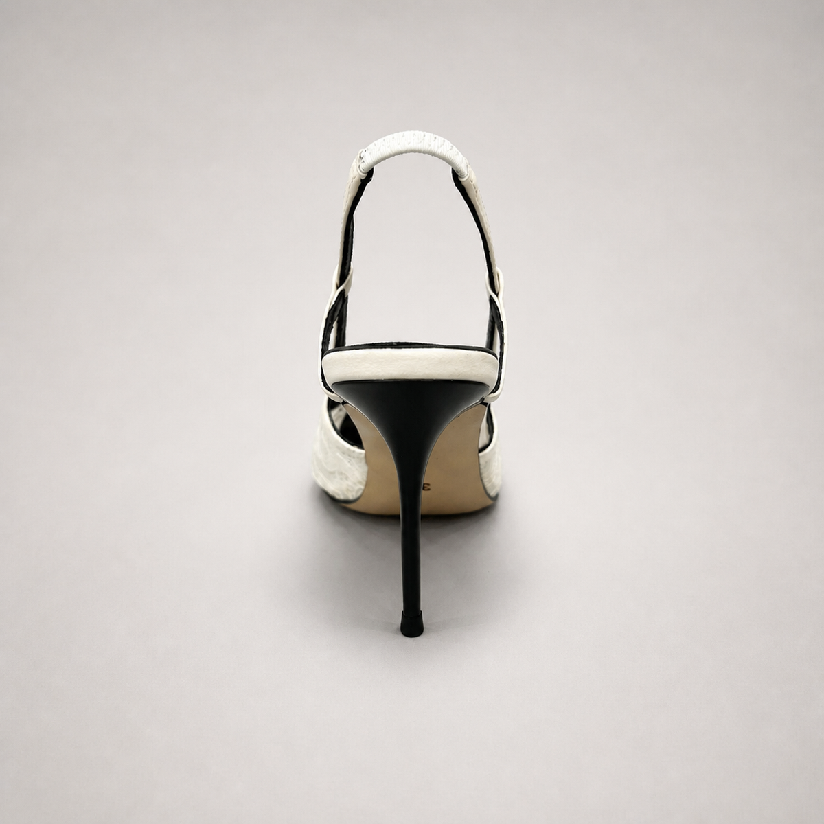 White slingback pump top view showing a pointed toe and lace-panel upper