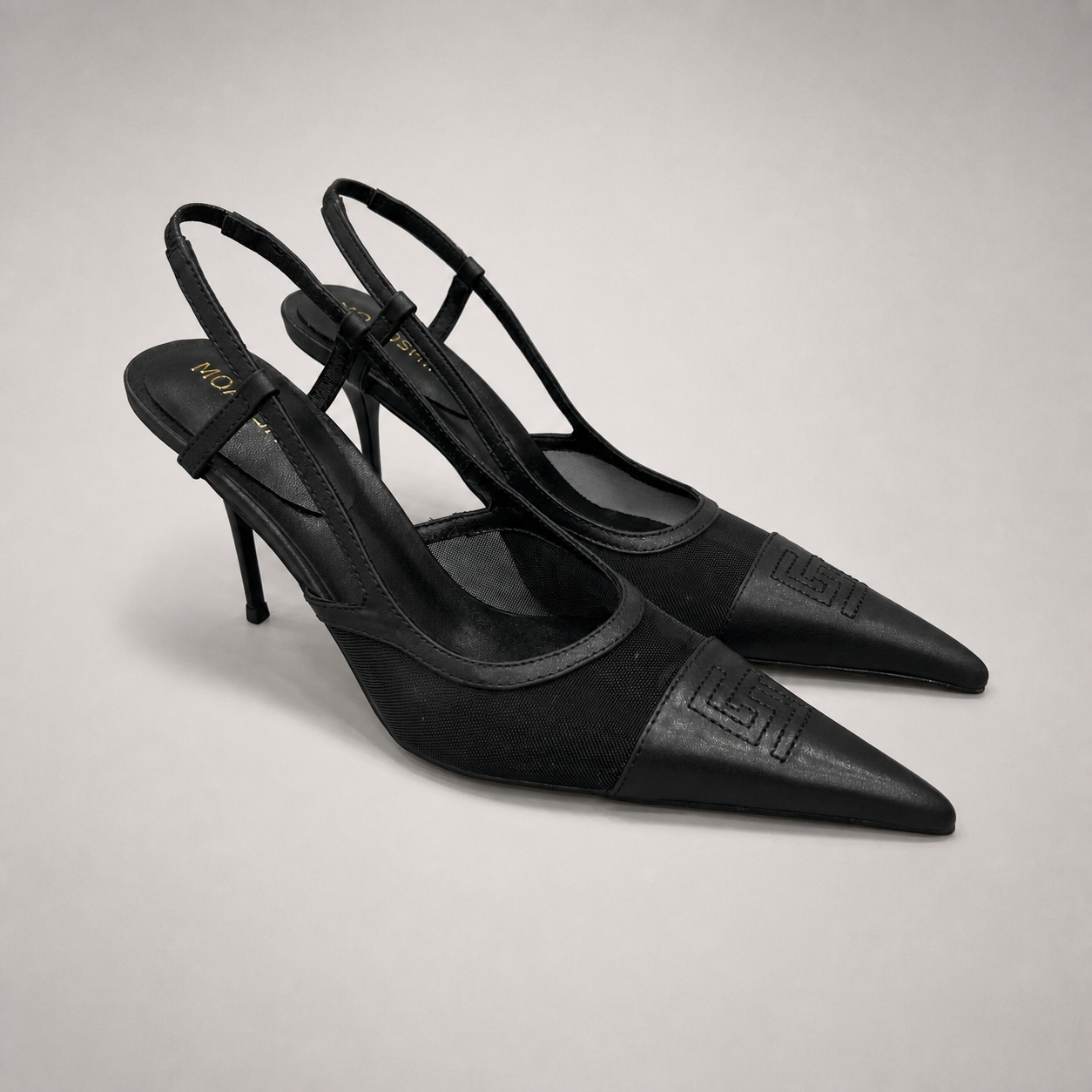 Black slingback pump pair three-quarter view showing a pointed toe and lace-panel upper