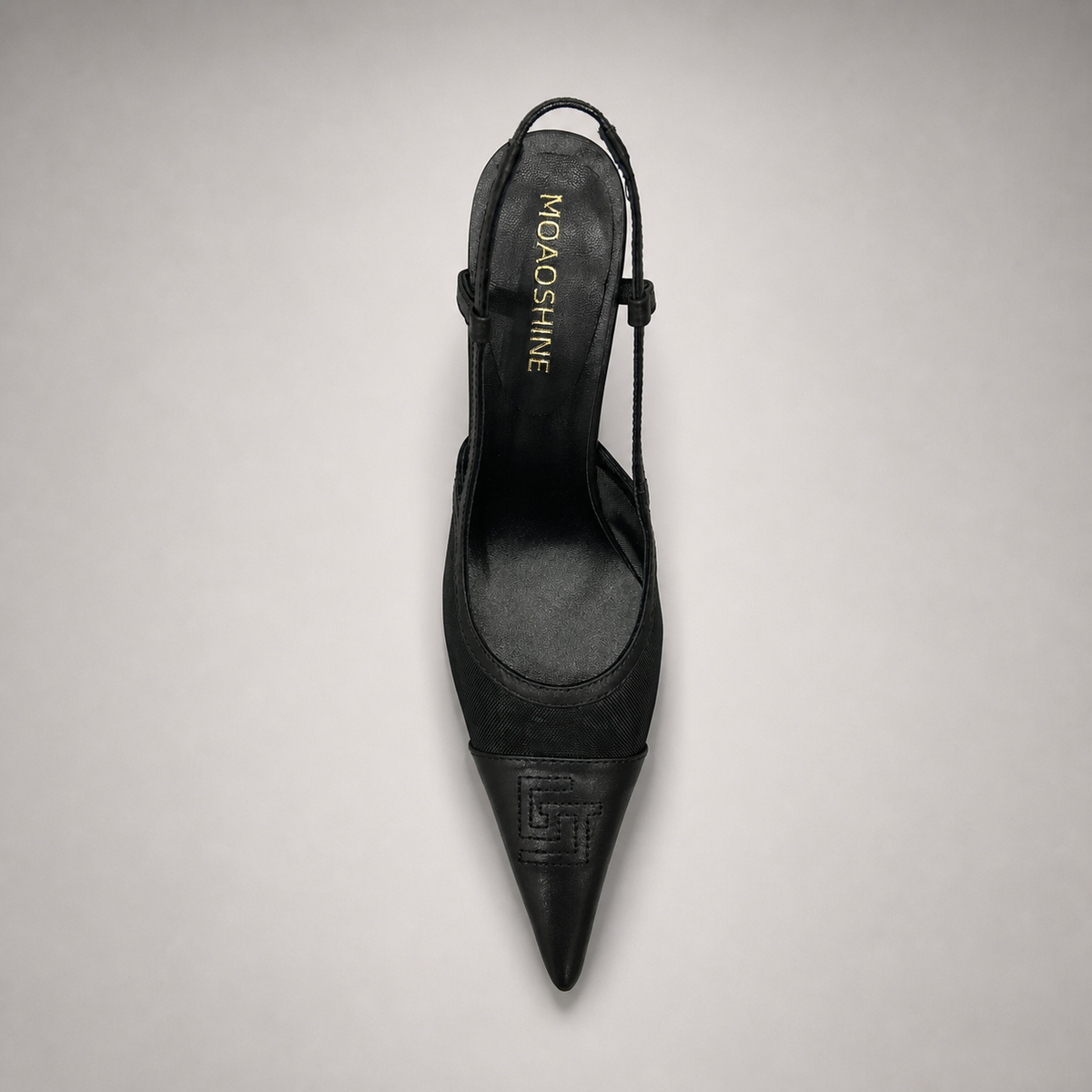 Black slingback pump top view showing a pointed toe and lace-panel upper