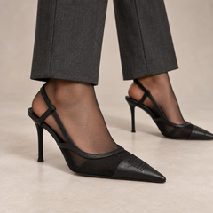 Black lace-panel pointed-toe slingback pumps worn with charcoal trousers