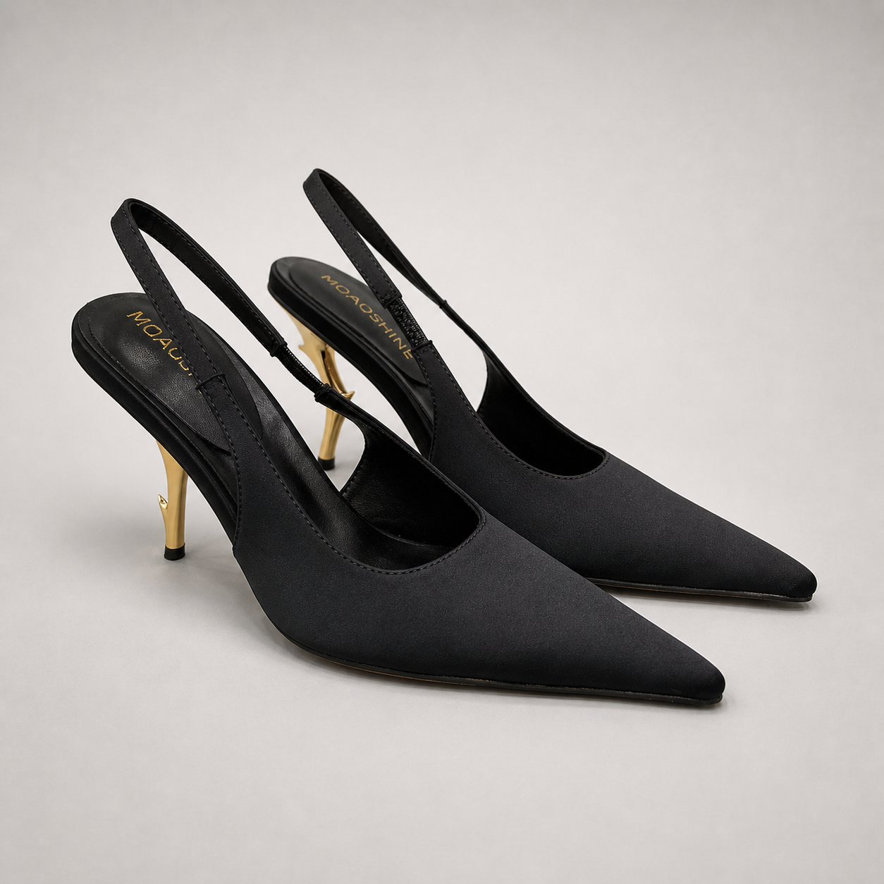 Black slingback pump pair three-quarter view showing a pointed toe and sculpted heel