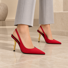 Red satin pointed-toe sculpted-heel slingback pumps worn with pale gray trousers