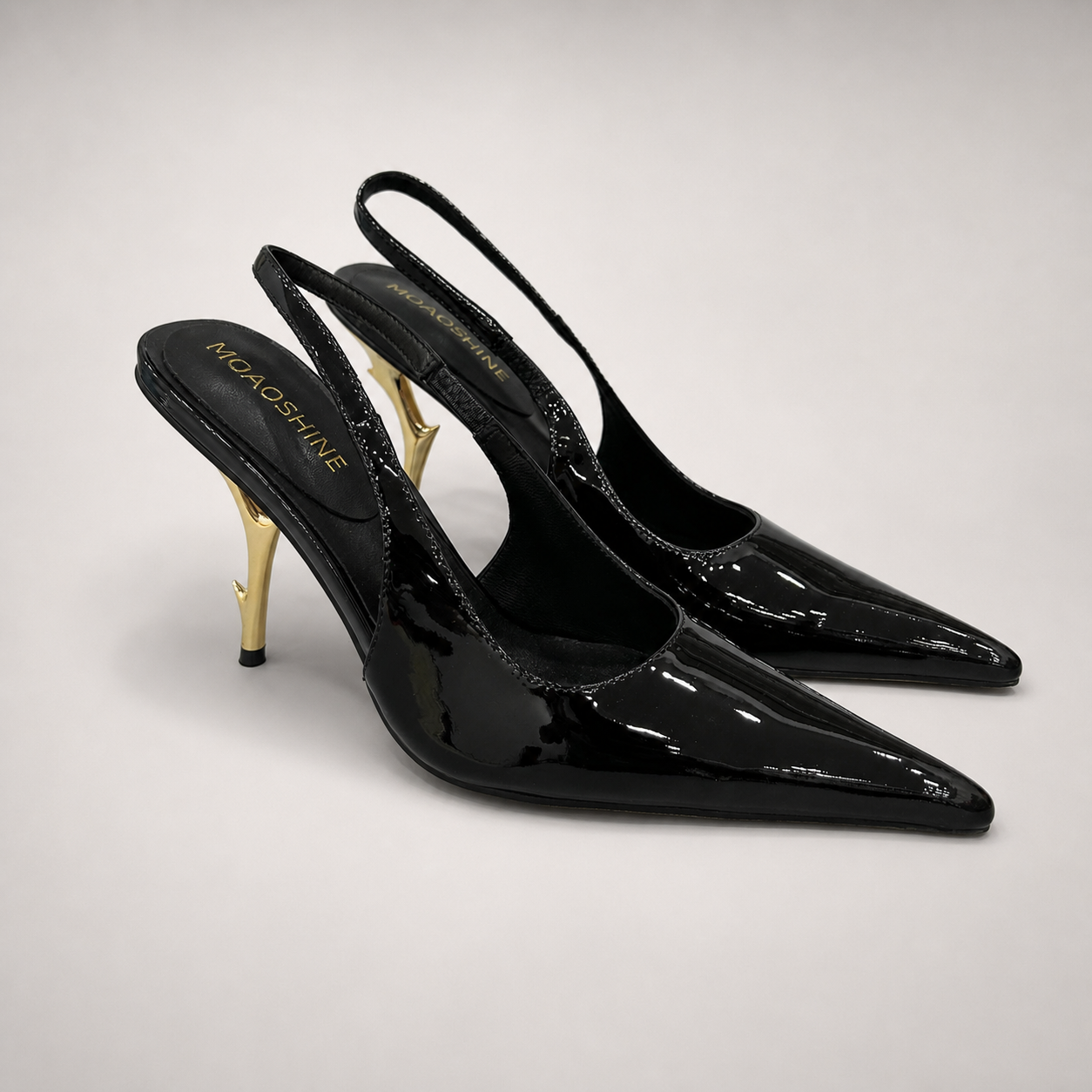 Black slingback pump pair three-quarter view showing a pointed toe and sculpted heel