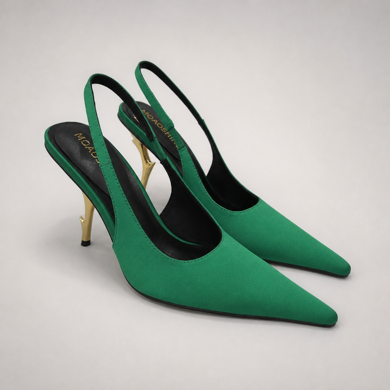 Green slingback pump pair three-quarter view showing a pointed toe and sculpted heel