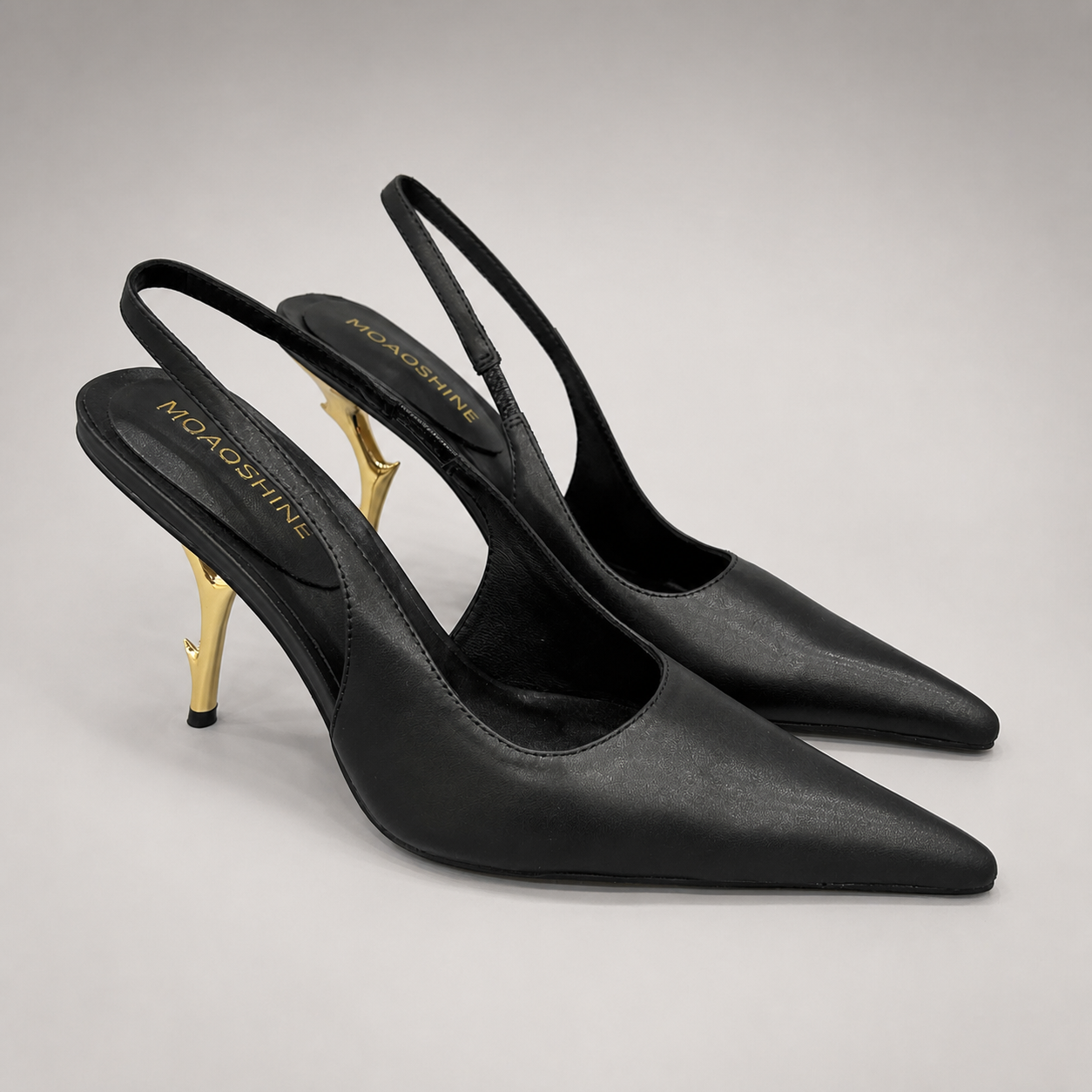 Black slingback pump pair three-quarter view showing a pointed toe and sculpted heel