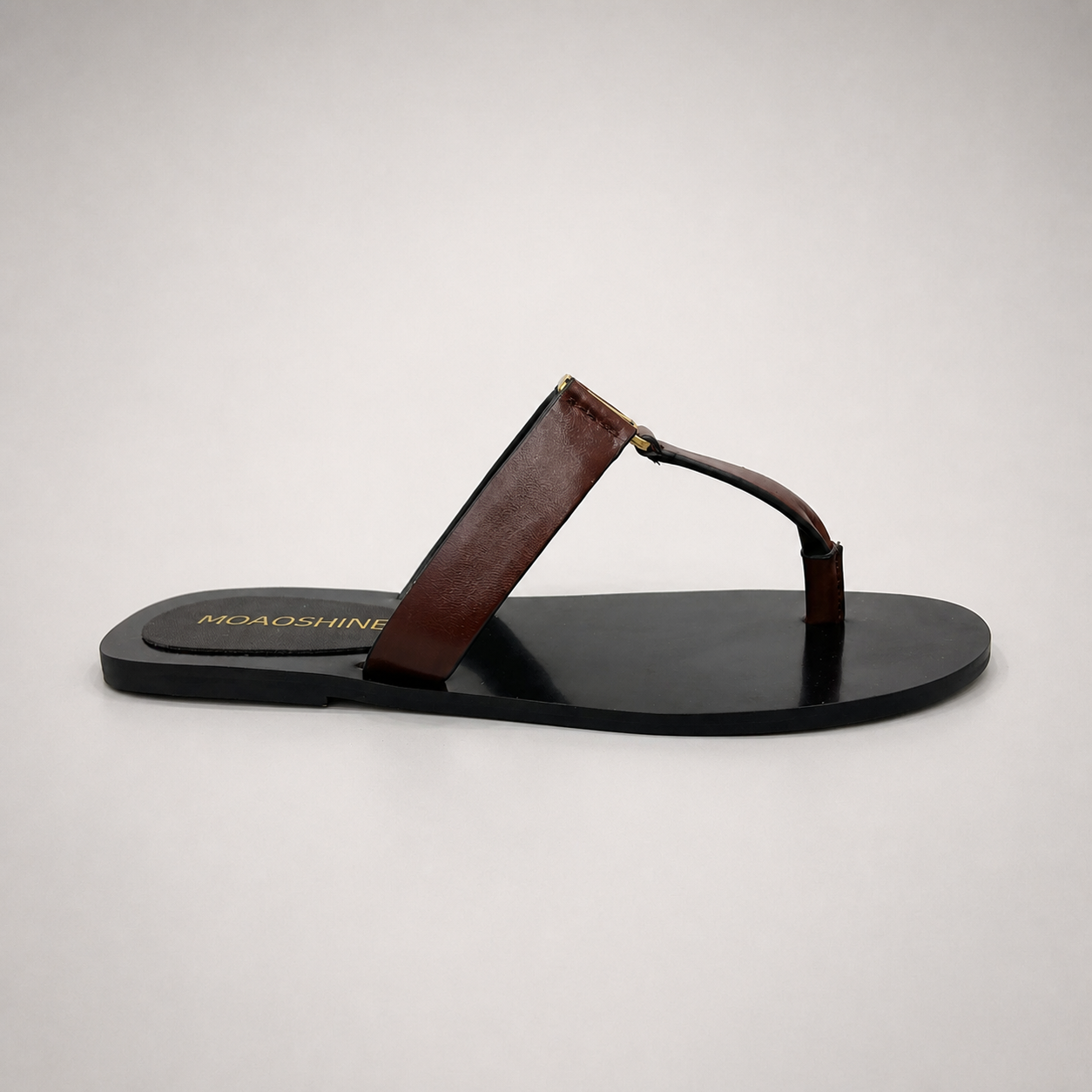 Brown flat sandal side profile showing a flat sole with a toe-loop strap