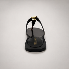 Brown flat sandal rear view showing a flat sole with a toe-loop strap