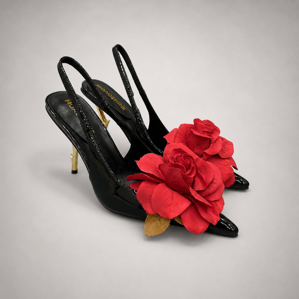 Black slingback pump pair three-quarter view showing a pointed toe and floral appliqué