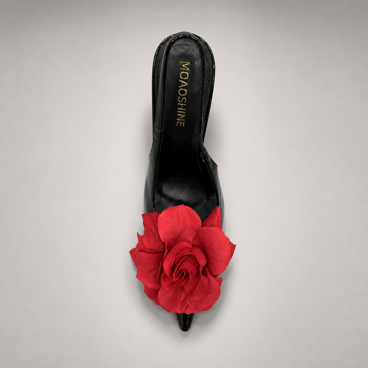 Black slingback pump rear view showing a pointed toe and floral appliqué