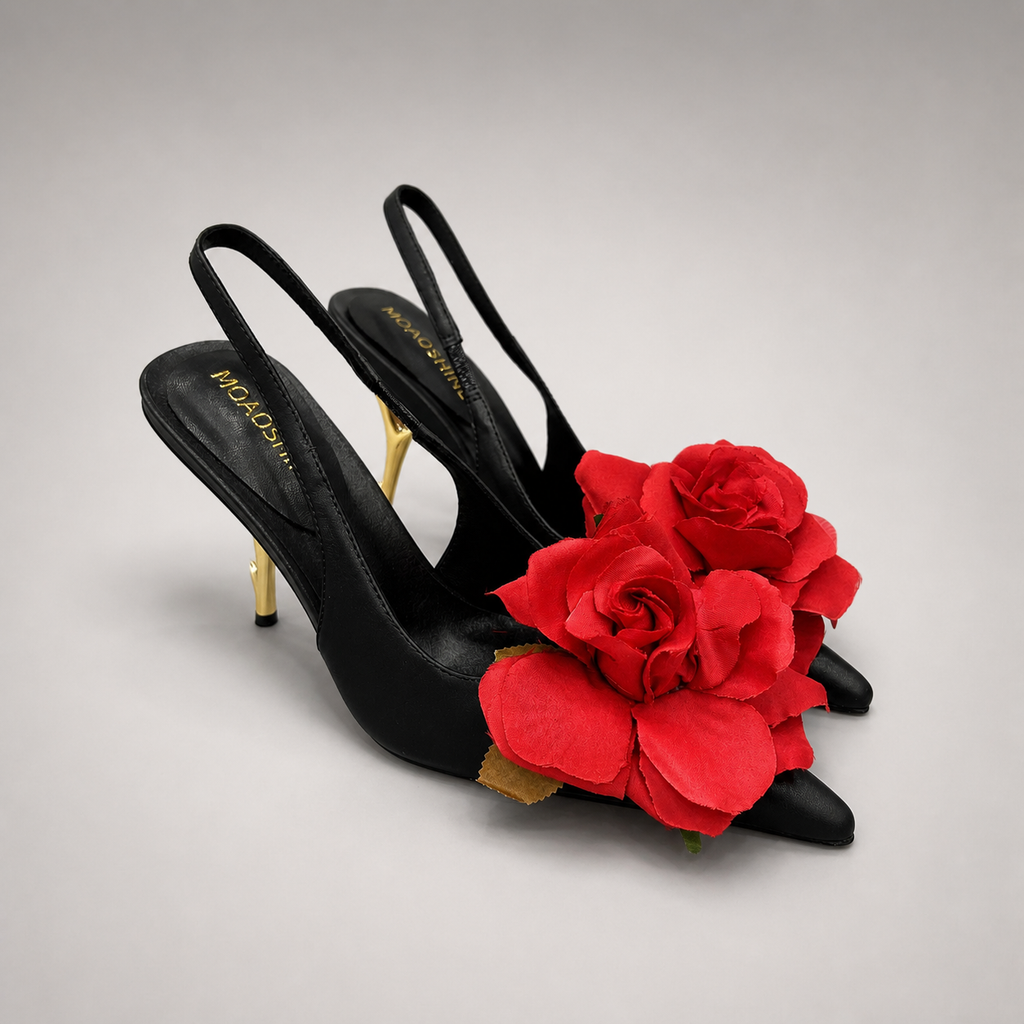 Black slingback pump pair three-quarter view showing a pointed toe and floral appliqué