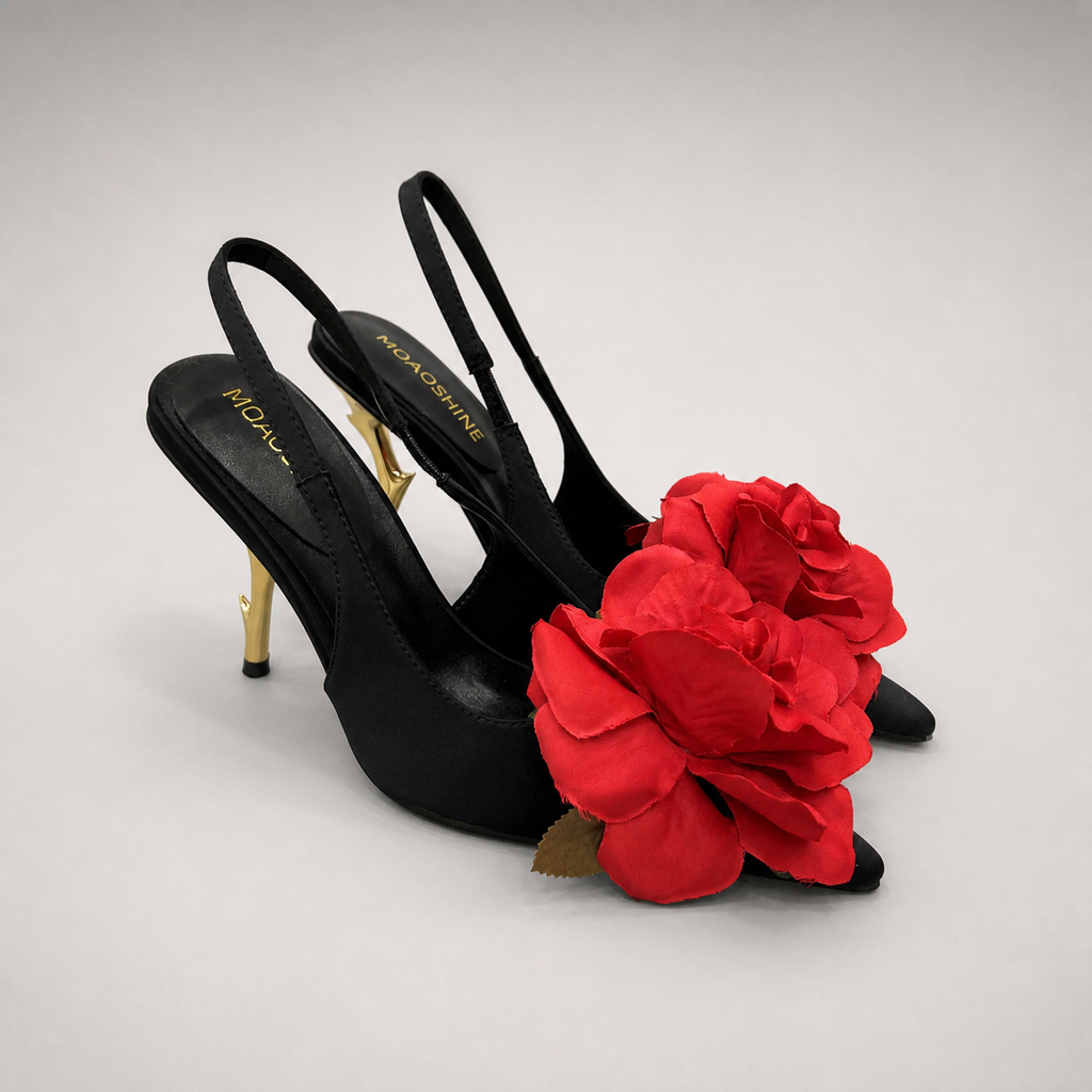 Black slingback pump pair three-quarter view showing a pointed toe and floral appliqué