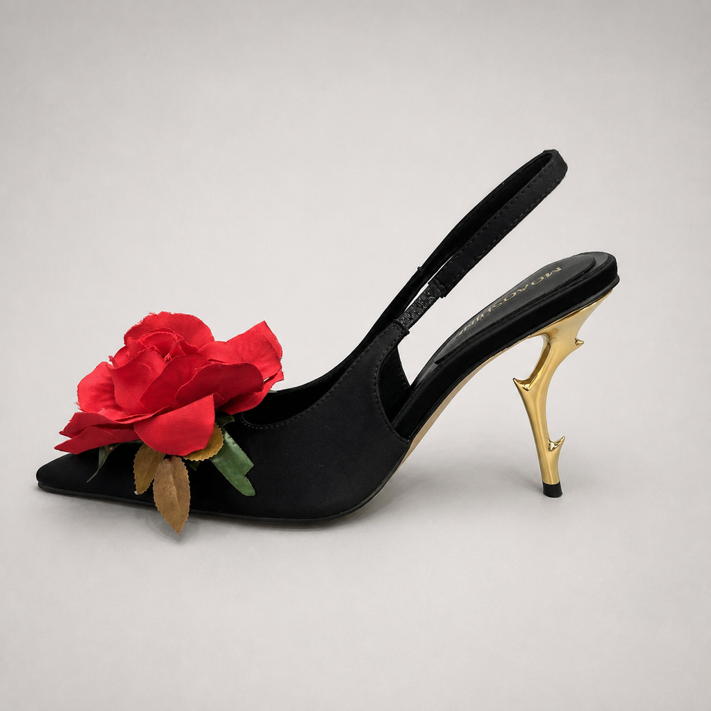 Black slingback pump opposite side profile showing a pointed toe and floral appliqué