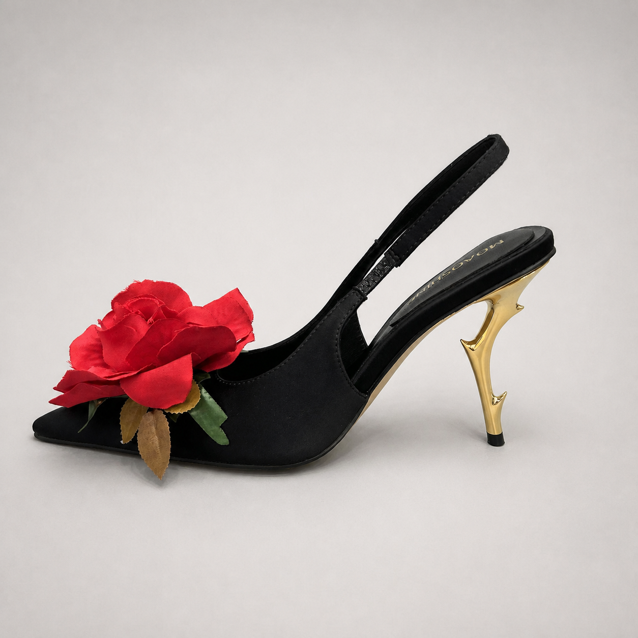 Black slingback pump opposite side profile showing a pointed toe and floral appliqué
