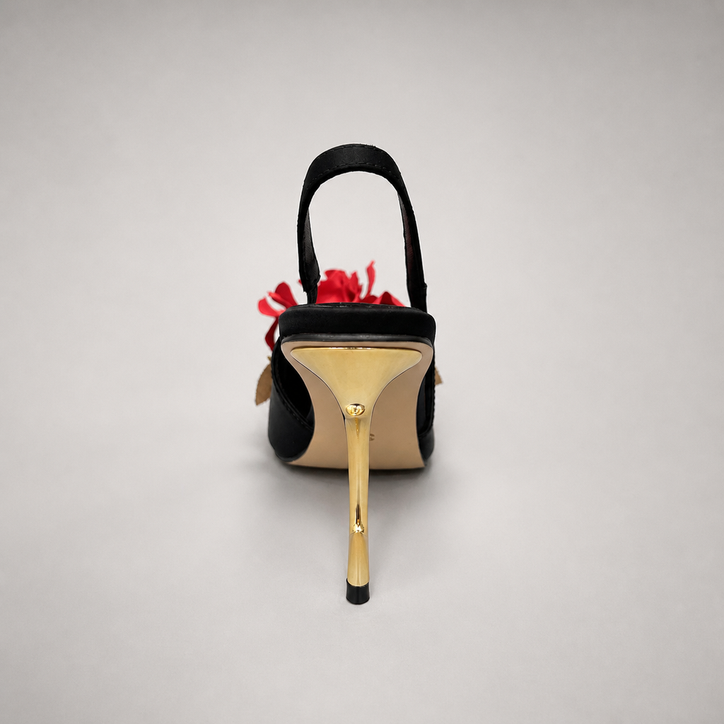 Black slingback pump rear view showing a pointed toe and floral appliqué