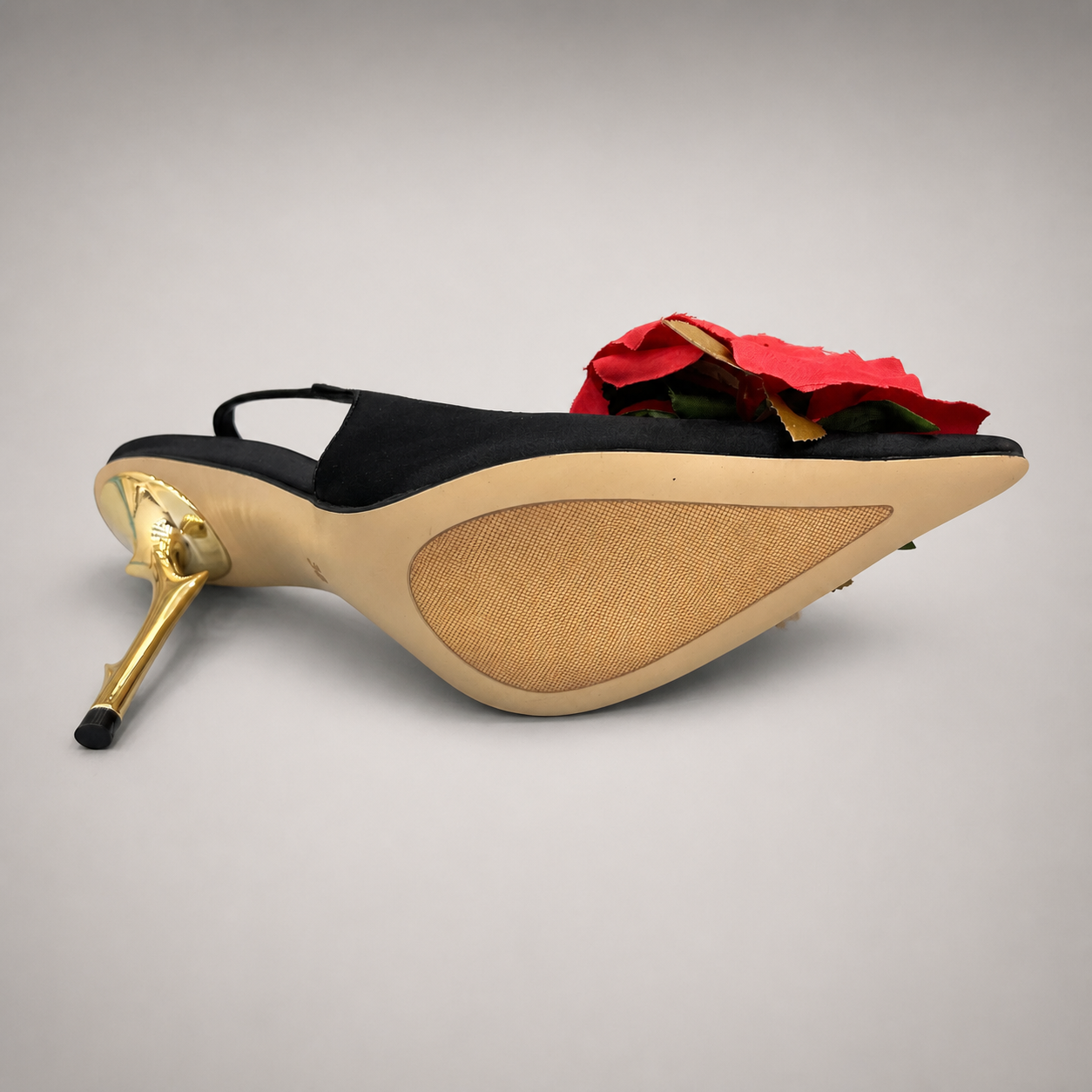 Black slingback pump top view showing a pointed toe and floral appliqué