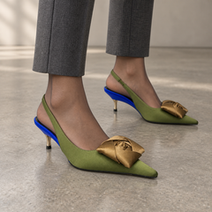 Olive satin pointed-toe bow slingback pumps worn with charcoal tailored trousers and sheer hosiery