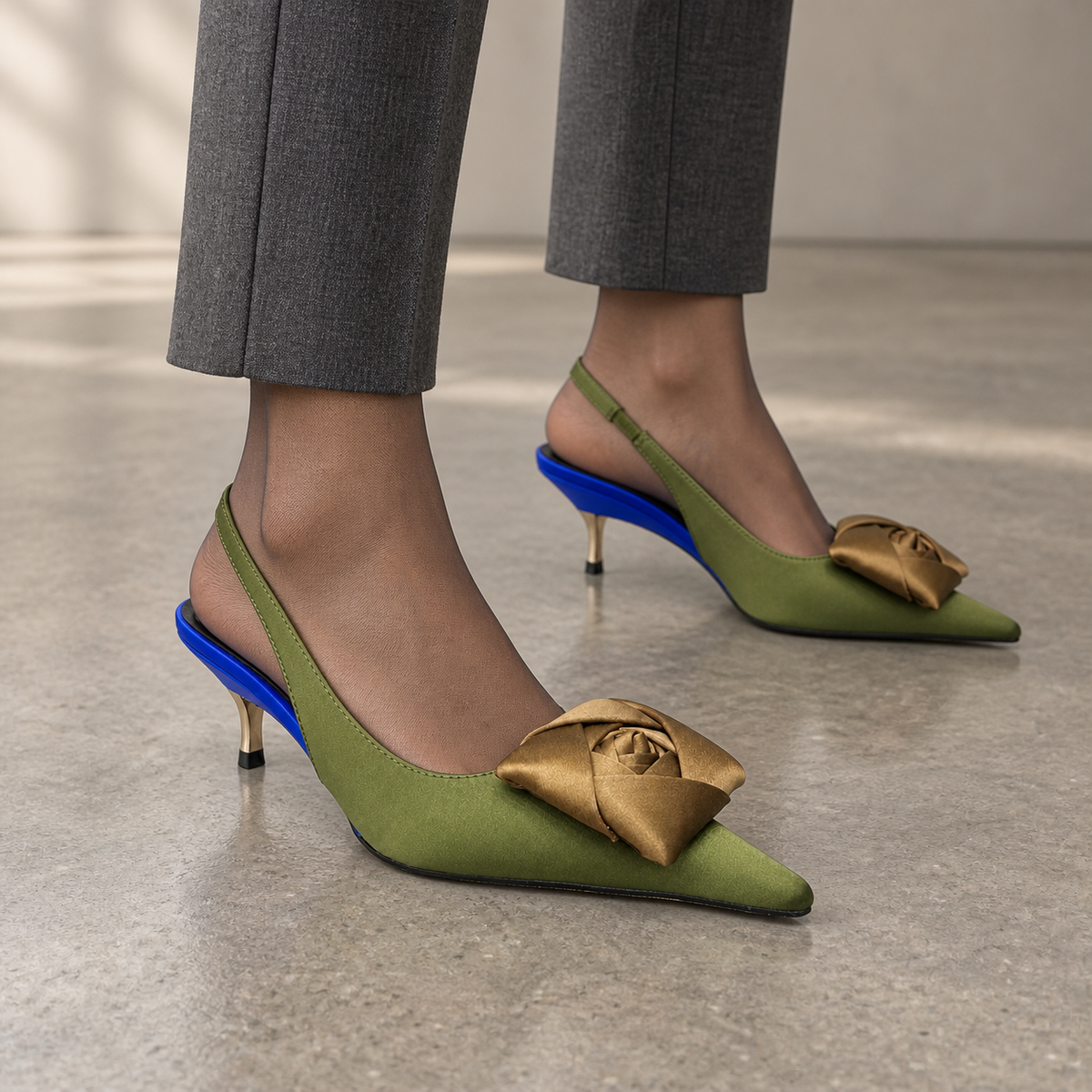 Olive satin pointed-toe bow slingback pumps worn with charcoal tailored trousers and sheer hosiery