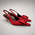 Red slingback pump pair three-quarter view showing a pointed toe and bow detail