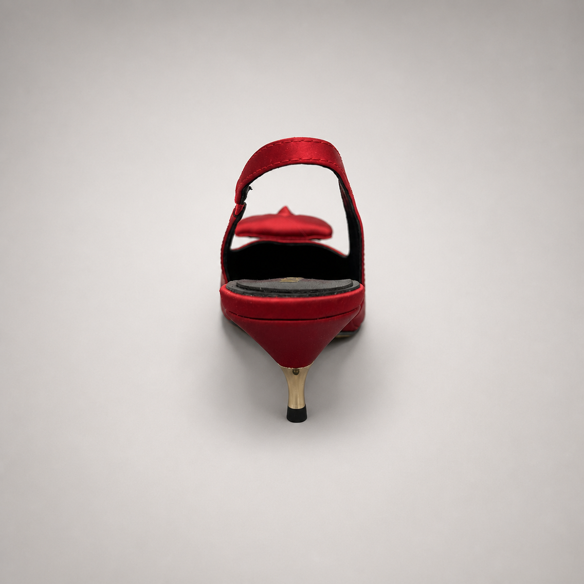 Red slingback pump rear view showing a pointed toe and bow detail